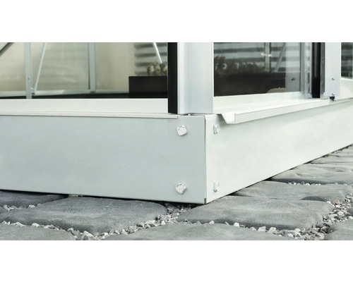 Vue détaillée d''une serre avec cadre de fondation sur des pavés