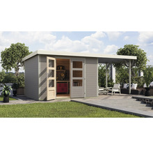 Abri de jardin avec établi, outils et coin salon extérieur sur pelouse