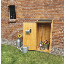 Holzgartenschrank mit Gartengeräten, Gießkanne und Sonnenblumen vor einer Backsteinmauer