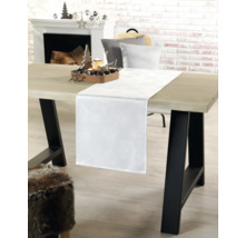 Table à manger décorée pour les fêtes avec chemin de table blanc, bougies et éléments décoratifs pour la période de Noël