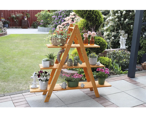 Holzpflanzenregal mit drei Ebenen, dekoriert mit Pflanzen und Dekorationen im Garten.