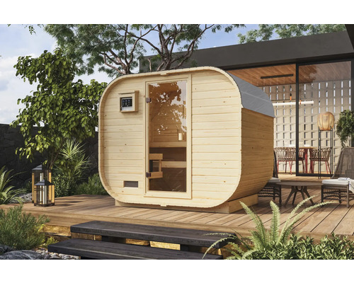 Sauna en forme de tonneau en bois avec porte en verre sur une terrasse dans le jardin.