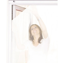 Frau montiert Insektenschutzgitter am Fenster.