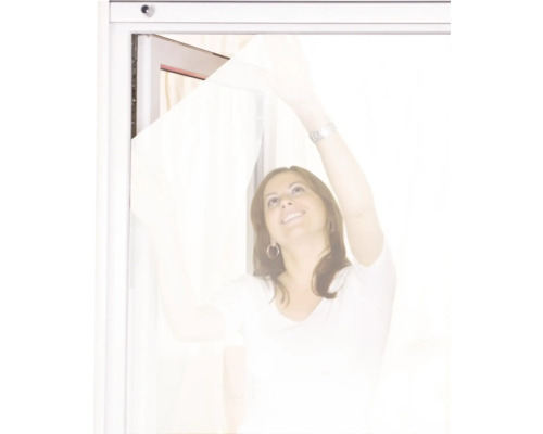 Frau montiert Insektenschutzgitter am Fenster.