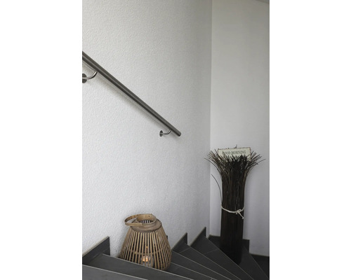 Treppenhaus mit Handlauf, dekorativer Laterne und Ziergras