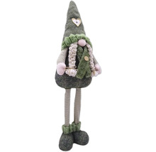 Dekorative Stoffpuppe mit Mütze und gestreiften Beinen als Weihnachtsdekoration