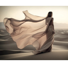 Eine Frau mit fließendem Kleid steht in einer Wüste.