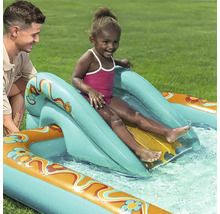Kind rutscht auf einer aufblasbaren Wasserrutsche in einem Pool