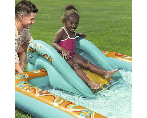 Kind rutscht auf einer aufblasbaren Wasserrutsche in einem Pool