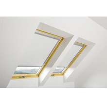 Deux fenêtres de toit avec stores dans une pièce lumineuse.