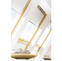 Fenêtres de toit avec stores dans une pièce mansardée lumineuse