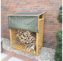 Holzlager mit Holz und Abdeckplane vor einer Ziegelwand