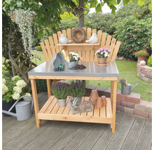 Scène de jardin avec une table de plantation en bois avec plateau en métal et accessoires de jardinage