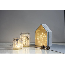 Scène décorative avec photophores en verre et une maison de calendrier de l''Avent, éclairée avec des lumières