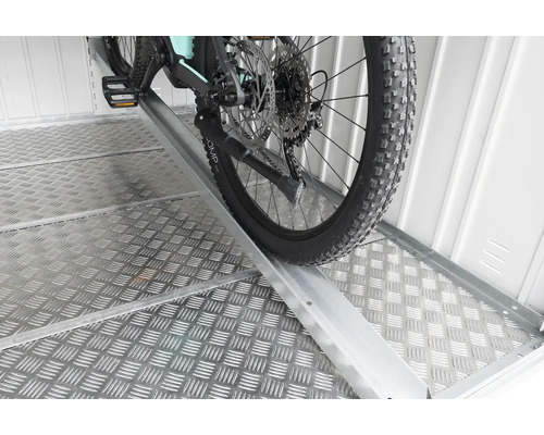 Vélo sur une rampe dans un espace de stockage.