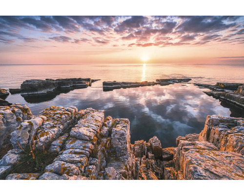 Paysage côtier rocheux au lever du soleil avec des eaux calmes