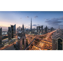 Skyline von Dubai mit Wolkenkratzern und beleuchteten Autobahnen bei Dämmerung