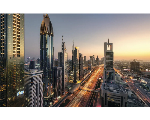 Panoramaaufnahme der Skyline von Dubai mit beleuchteten Wolkenkratzern und Straßenverkehr bei Dämmerung.