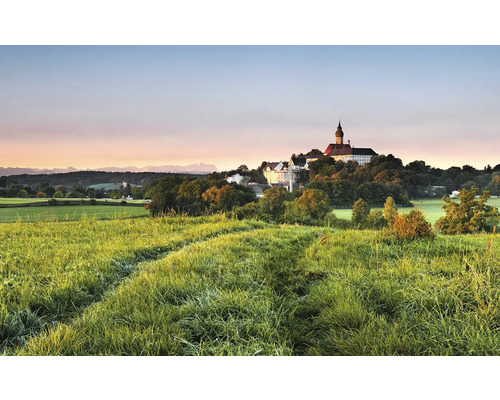 Landschaft mit Wiese und Gebäude auf einem Hügel