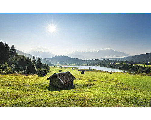 Landschaft mit Wiese, See und Holzhütten