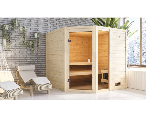 Sauna aus Holz mit Glastür neben Entspannungsliegen in einem hellen Raum.
