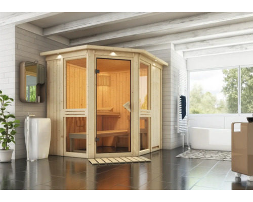 Sauna modulaire Karibu Omelia 1 avec poêle 9 kW et commande intégrée avec couronne et portes entièrement vitrées coloris bronze Sauna en bois avec porte en verre dans une salle de bain avec lavabo et baignoire.