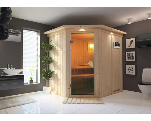 Sauna Plug & Play Karibu Achat VII avec poêle bio 3,6 kW et commande ext., avec couronne et porte entièrement vitrée coloris bronze Sauna d'angle dans salle de bains avec lavabo, toilettes et décoration