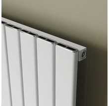 Weißer Heizkörper mit vertikalen Paneelen an einer Wand