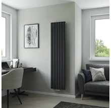 Salon moderne avec radiateur vertical, bureau et canapé.