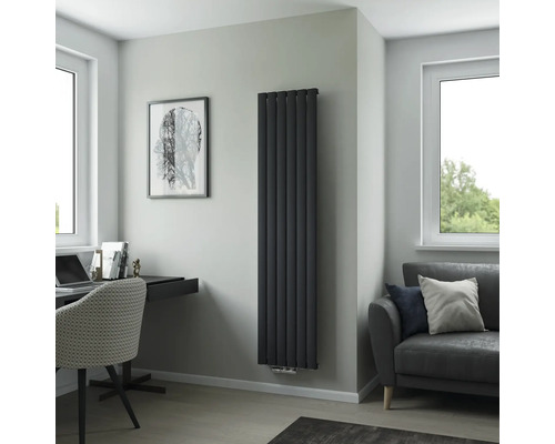 Salon moderne avec radiateur vertical, bureau et canapé.