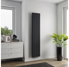 Hoher, schmaler Heizkörper an einer Wand in einem Raum.