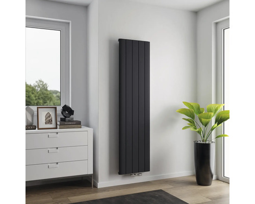 Radiateur vertical à panneaux dans une pièce moderne à côté d'une fenêtre et d'une commode