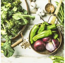 Scène avec des légumes, dont du brocoli, des poivrons verts et des oignons rouges dans des bols