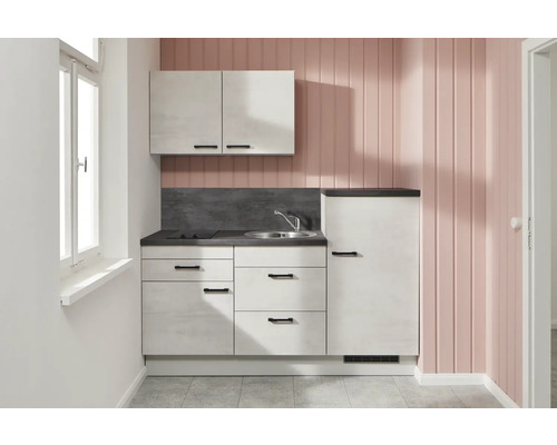 Petite kitchenette avec évier, plaque de cuisson, armoire suspendue et réfrigérateur dans une pièce lumineuse.