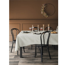 Esstisch mit Gedeck, Stühlen und floralem Wandkranz in einem Esszimmer.