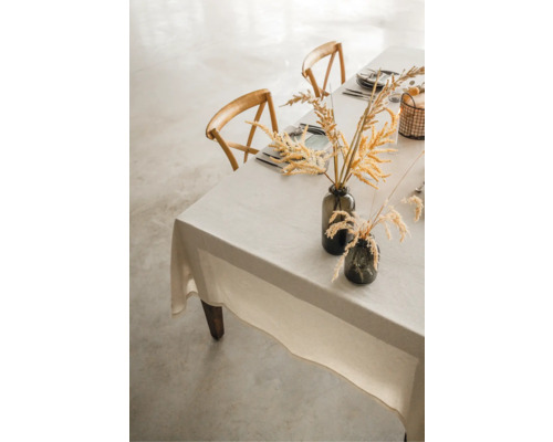 Gedeckter Tisch mit Tischdecke, Vasen und Holzstühlen