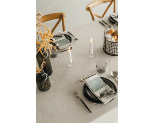 Dekorierter Esstisch mit Geschirr, Kerzen, Blumenvase und Speisen