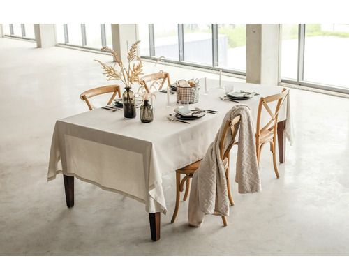 Gedeckter Esstisch mit Tischdecke, Geschirr, Dekoration und Stühlen