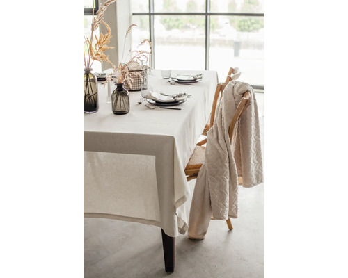 Gedeckter Esstisch mit Tischdecke, Geschirr und Dekoration