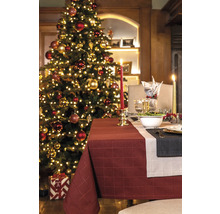 Festlich gedeckter Tisch mit Weihnachtsbaum und Tischdecke für eine weihnachtliche Atmosphäre.