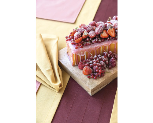 Kuchen mit Guss und verschiedenen Beeren auf einem Holzbrett
