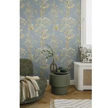 Dekoratives Wohnzimmer mit floral gemusterter Tapete, Sessel und Beistelltisch.