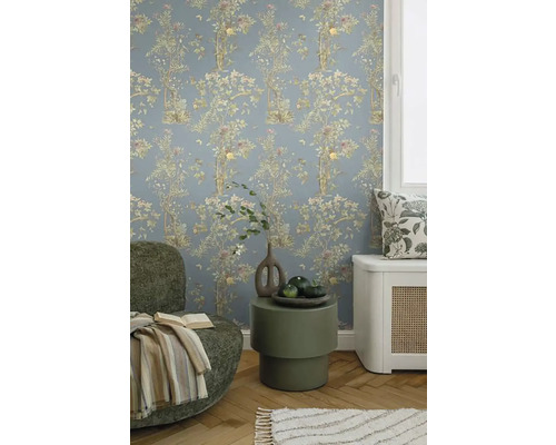 Dekoratives Wohnzimmer mit floral gemusterter Tapete, Sessel und Beistelltisch.
