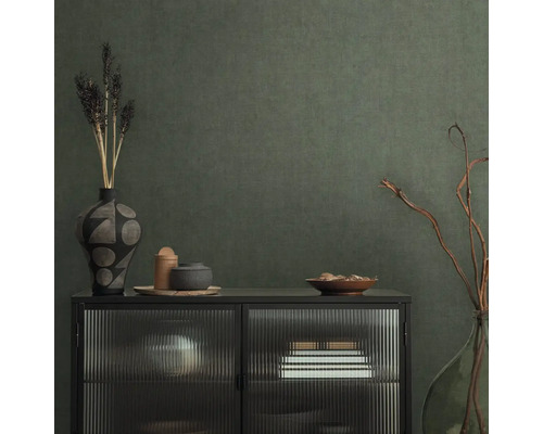 Buffet décoratif avec vases et coupelles devant un mur structuré
