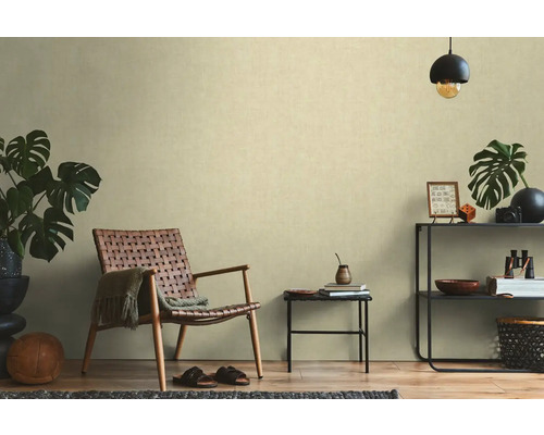 Salon avec fauteuil en rotin, table d'appoint et étagère avec décorations pour une ambiance chaleureuse.