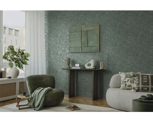 Wohnzimmer mit grüner Blättertapete, Sessel und Sofa
