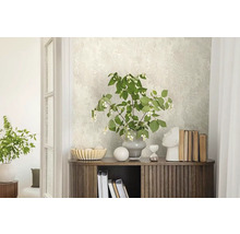 Dekorativer Raum mit gemusterter Tapete, Holzkommode und floralem Arrangement.