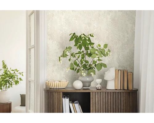 Dekorativer Raum mit gemusterter Tapete, Holzkommode und floralem Arrangement.