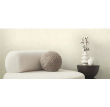 Dekorative Szene mit Sessel, rundem Kissen, Vase mit Baumwollzweigen und Tisch