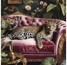 Un léopard est allongé sur un canapé rouge devant une décoration florale.